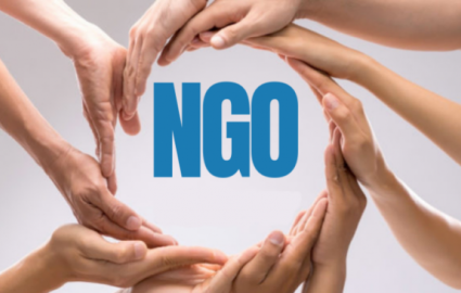 Napis NGO otoczony splecionymi w okrąg dłońmi.