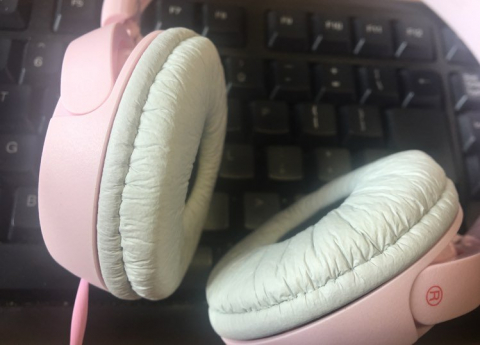 różowe słuchawki na czarnej klawiaturze komputerowej 